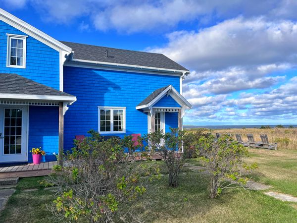 Grande maison chaleureuse aux Iles-de-la-Madeleine, à côté d’un petit port de pêche, vue sur la mer