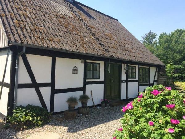 Hyggeligt bindingsværkhus ved skov og strand.