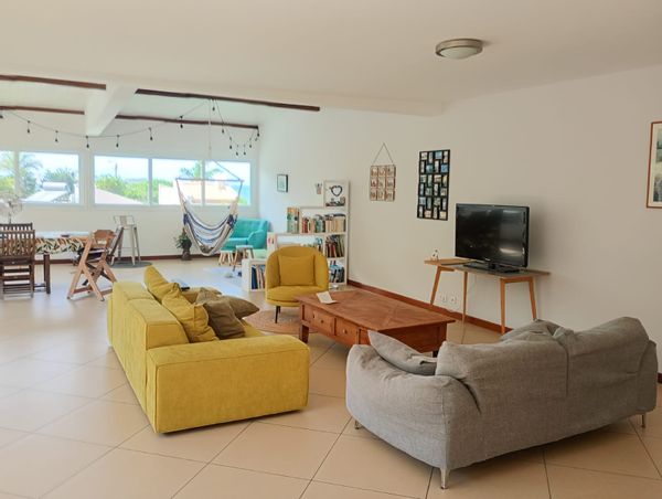 Grande pièce de vie très agréable ouverte sur le lagon et la végétation alentour.