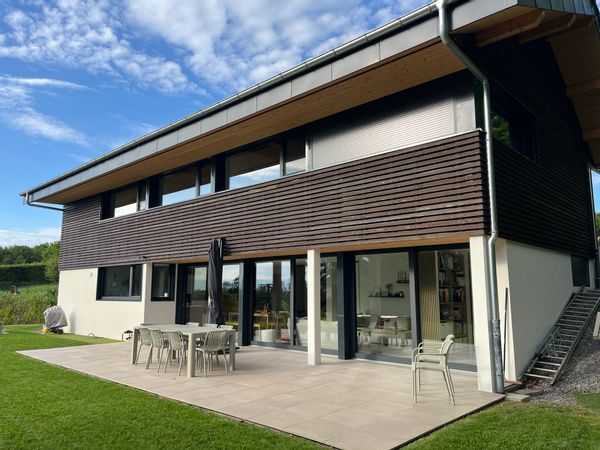 Maison dans la forêt entre lac et montagnes