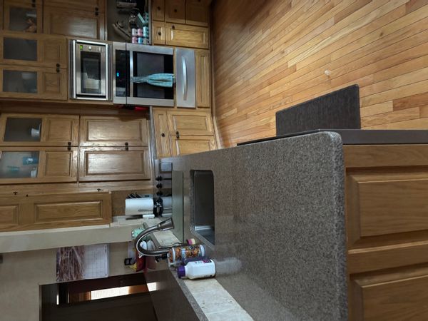 Ashley's house is a charming expansive hobby farm, with horses and chickens in the middle of a cornfield with a large front yard and a trampoline, with a swingset and toys for the kids.