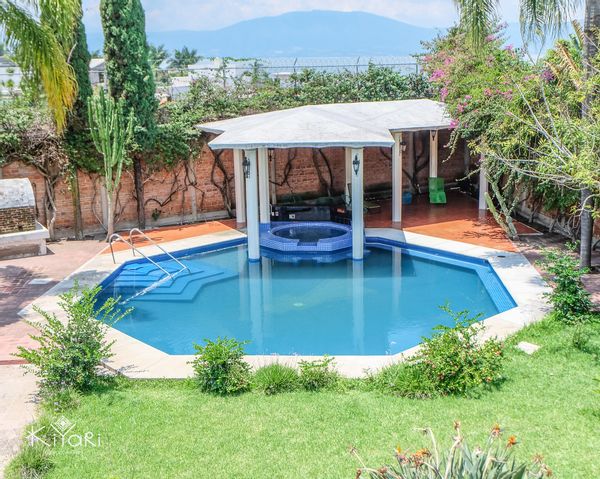 Casa de paz entre piscina y jardín