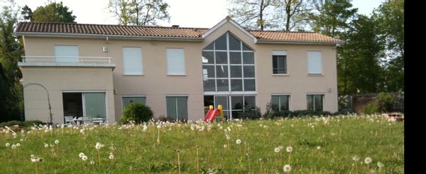 Près de Lyon, 2 chambres dans maison de 2 étages avec une véranda au centre et alentours arborés.