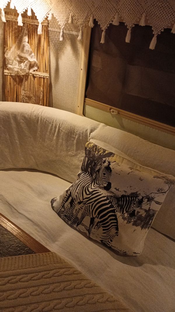 Roulotte in stile boho in riva al lago immersa nella natura per una esperienza di relax.