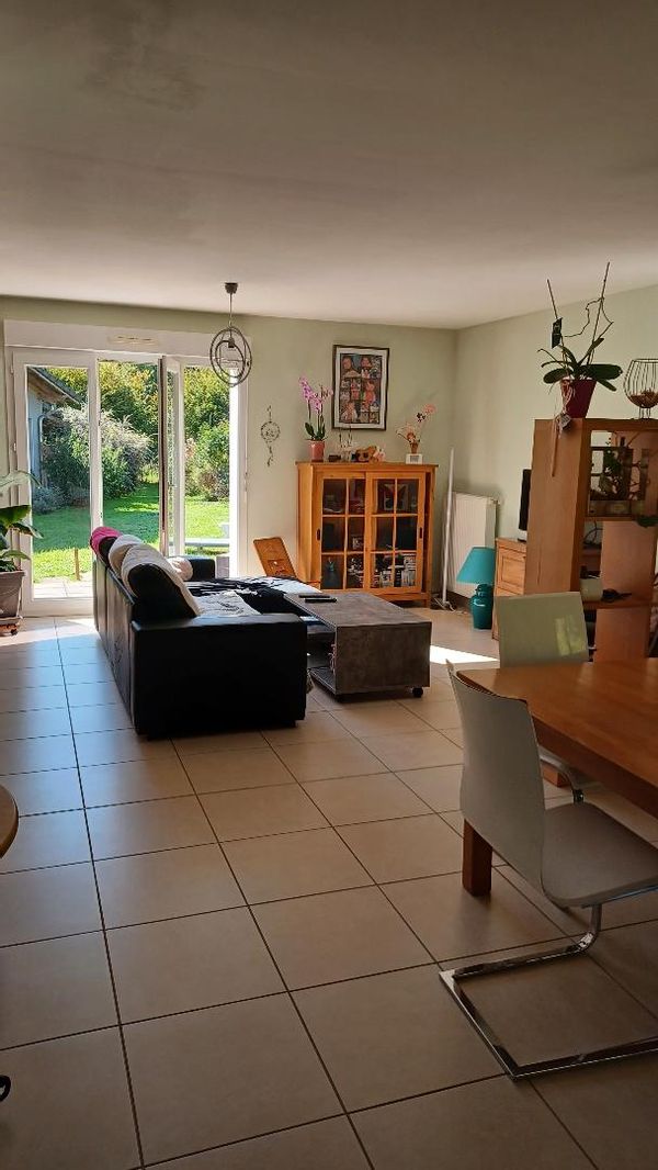 Maison de plein pied à l'abris des regards avec un beau jardin bien arboré et une terrasse au sud.