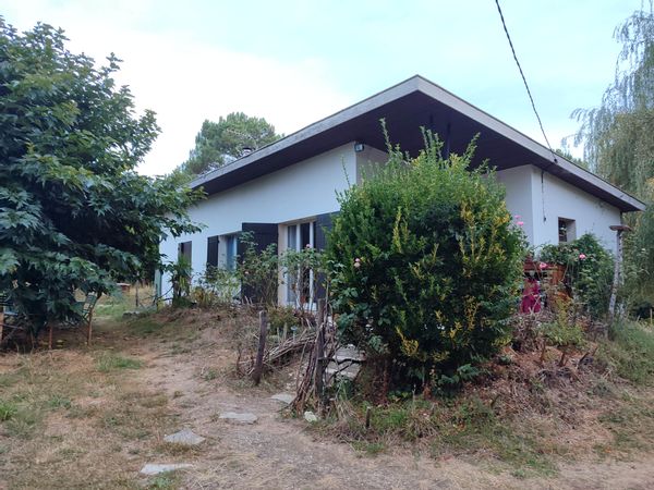 La maison dans la verdure avec verger et bosquet