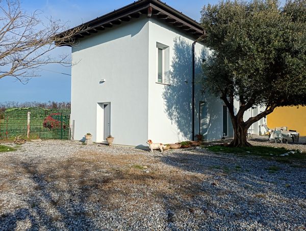Casa in campagna vicino al Lago di Garda. Nei dintorni campi e in lontananza le montagne.