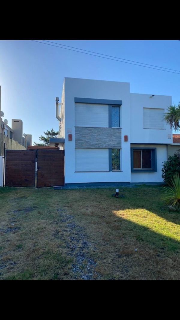 Vidrios de colores , casa de dos plantas , entrada de garage y cerco vivo casa blanca con palmera