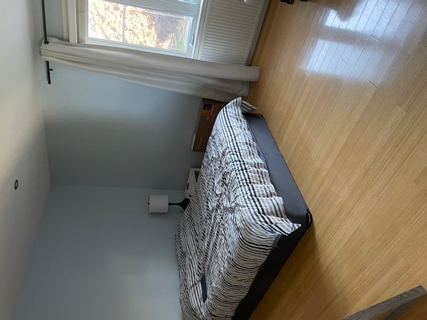 Bright and comfortable bedroom with a  queen-size bed and natural light. The room is comfortable