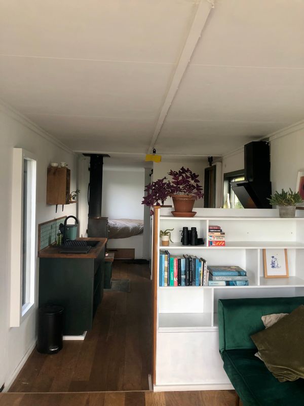 Verbouwde, knusse vrachtwagen met uitzicht over een bloemrijke tuin.