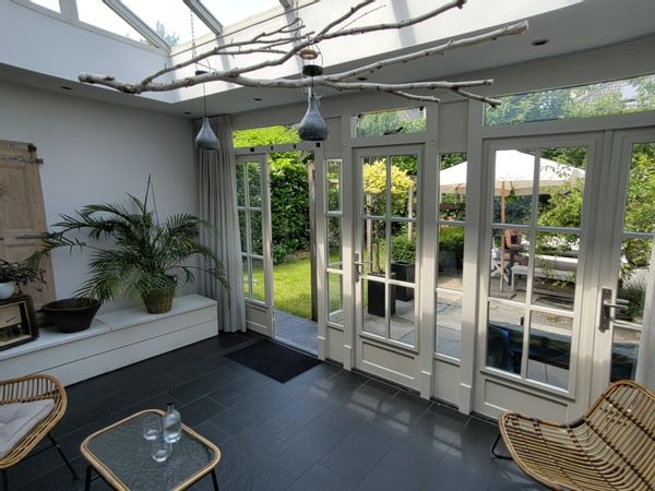 Casa amplia en la Veluwe con porche acristalado, jardín y parking, cerca ciudad y naturaleza.
